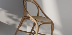 Rendu 3D d'une chaise en bois cintré et assise cannée sur fond neutre avec ombre portée, exemple de visuel produit photoréaliste